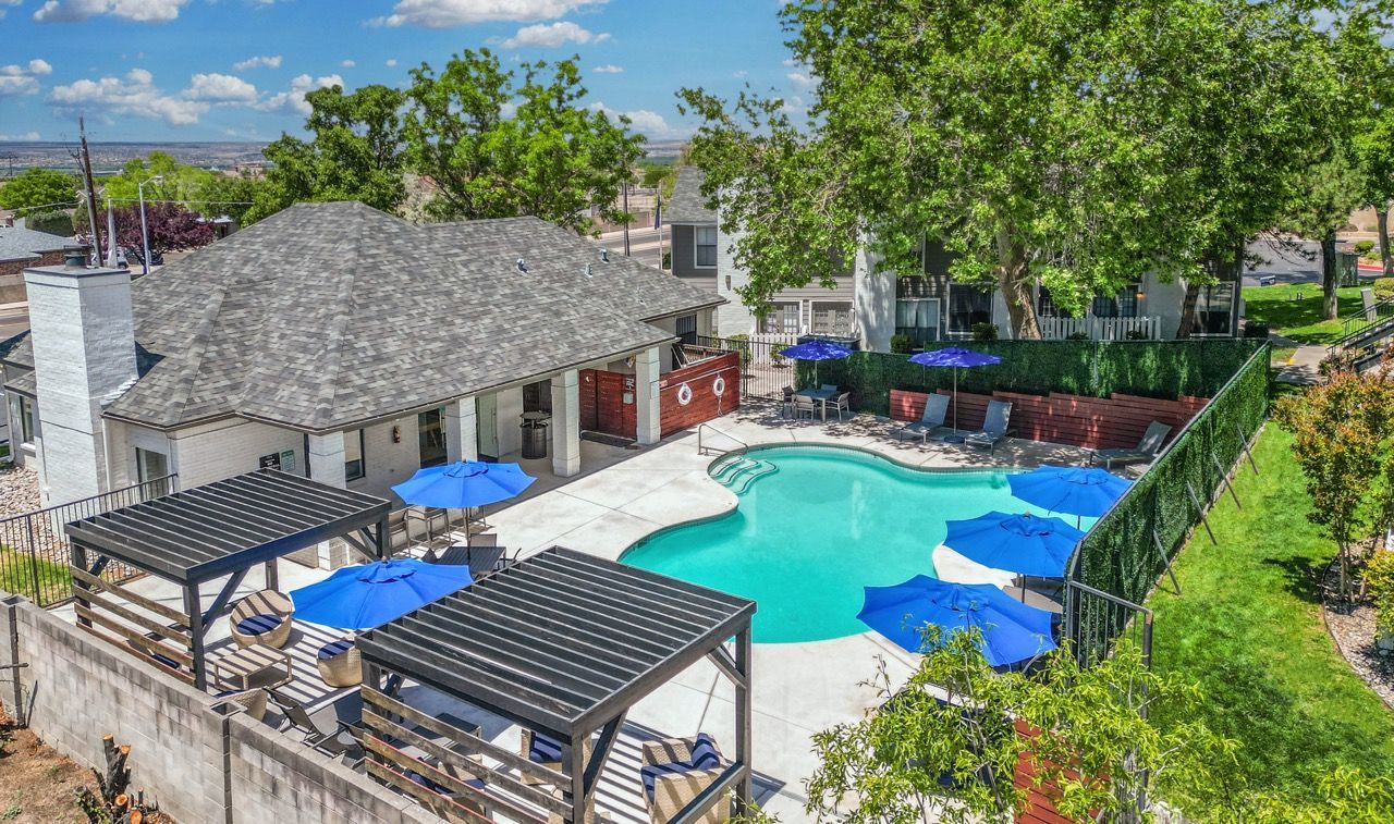Telegraph Hill  Aerial view of community pool area with blue umbrellas, lounge chairs, and surrounding buildings.