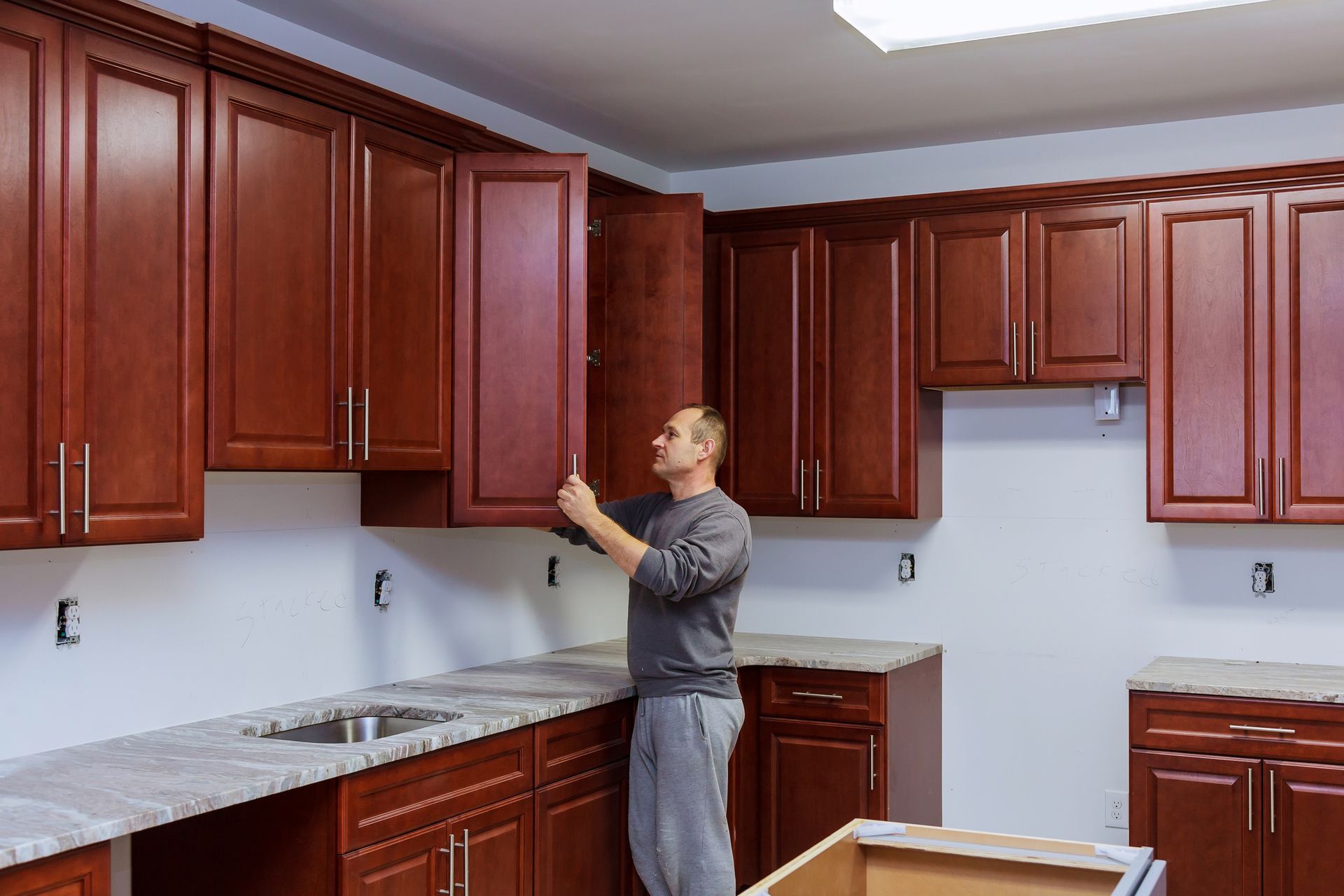 A home worker sets a new handle on the cabinet.