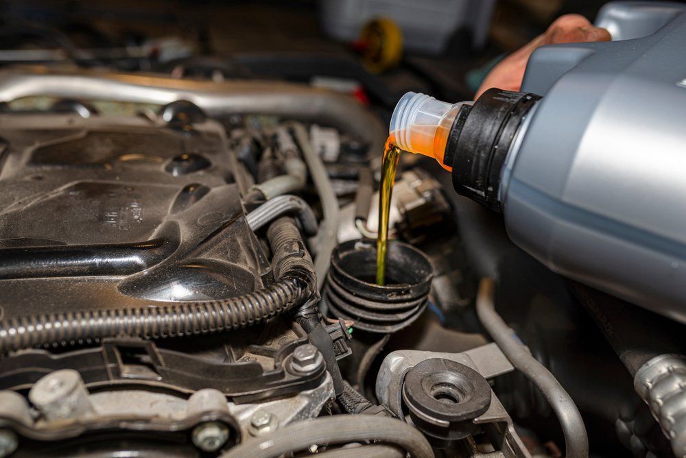 Car Mechanic Pours New Car Oil Into The Engine — Roadside Auto Care In Maroochydore QLD