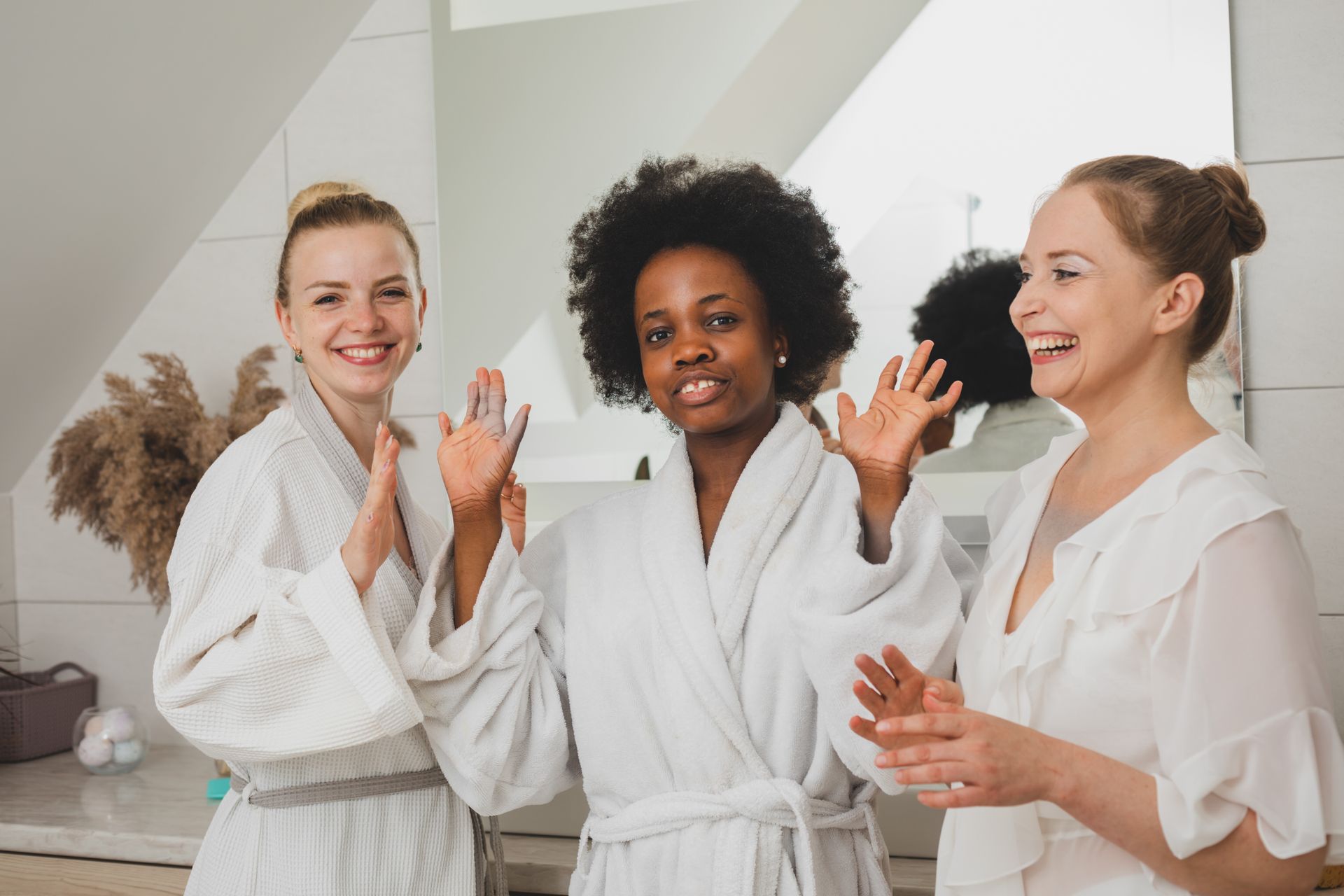 Three women are laying down with face masks on their faces.