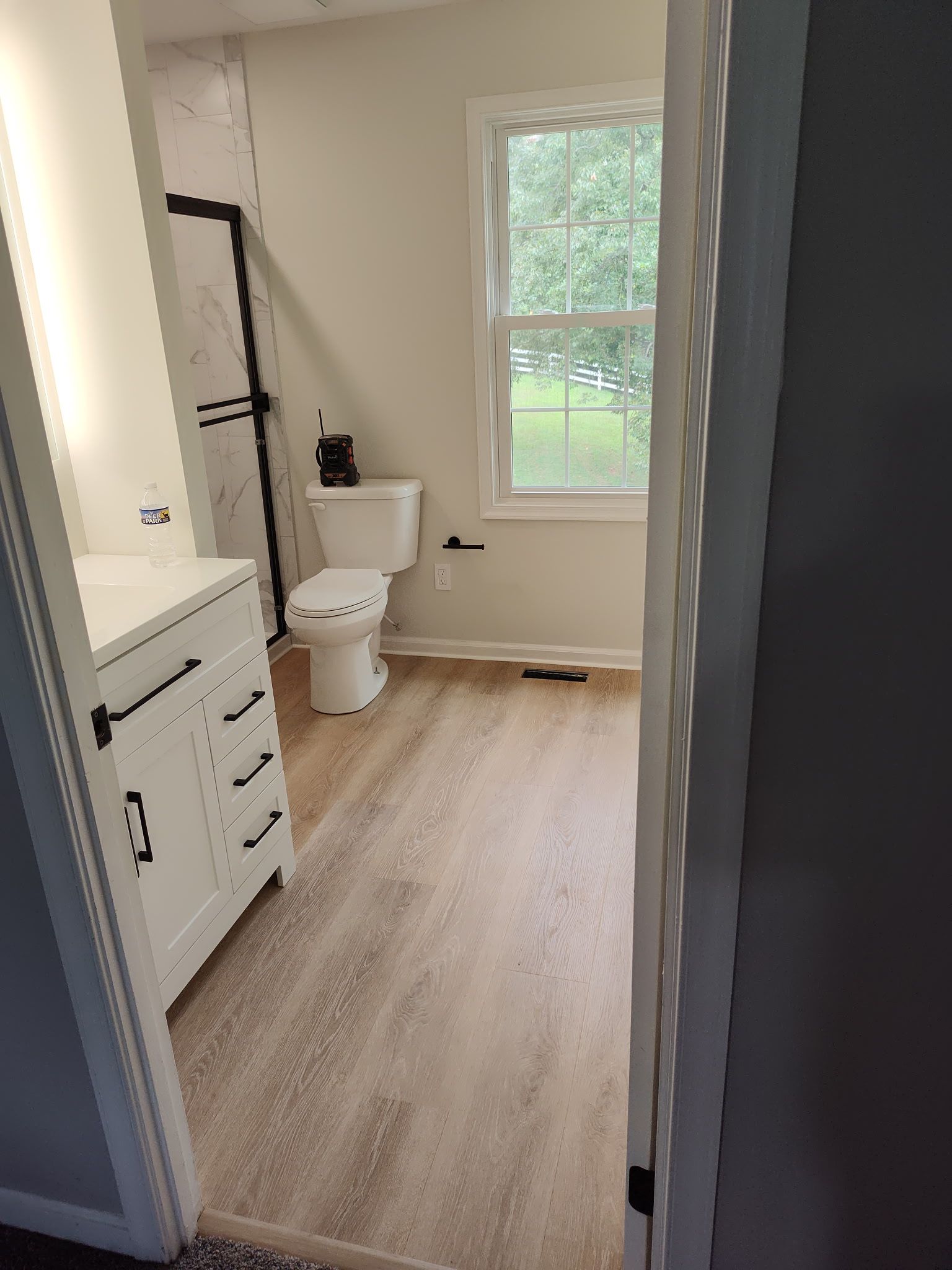 A remodeled bathroom with a toilet , sink , and window.