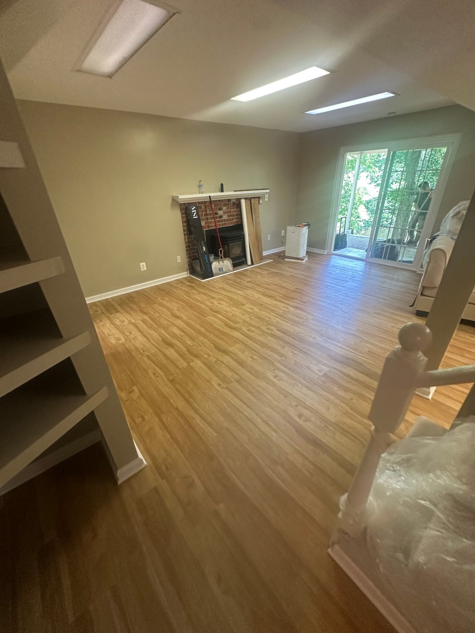 A basement living area with hardwood floors and a fireplace.