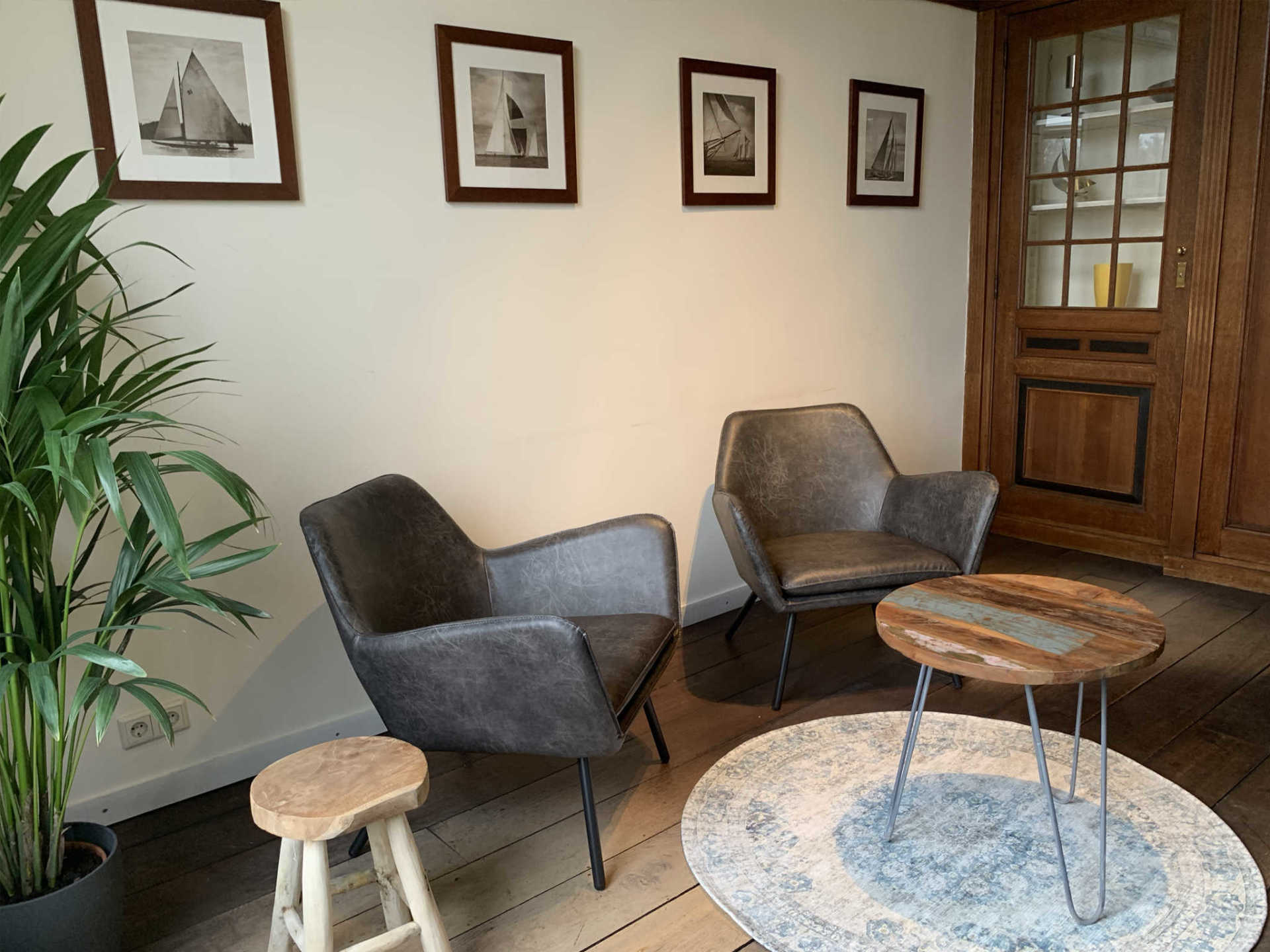 Een woonkamer met twee stoelen, een tafel en een plant.