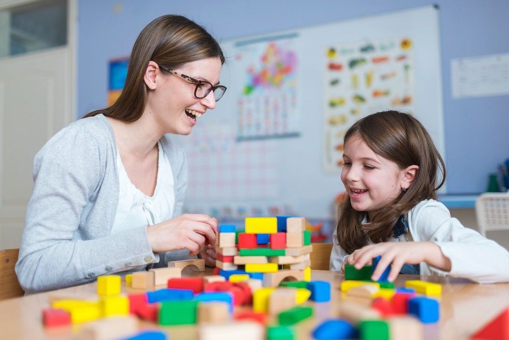 A Woman and a Little Girl Are Playing With Wooden Blocks at a Table — Woodlands Child Care Centre in East Albury, NSW