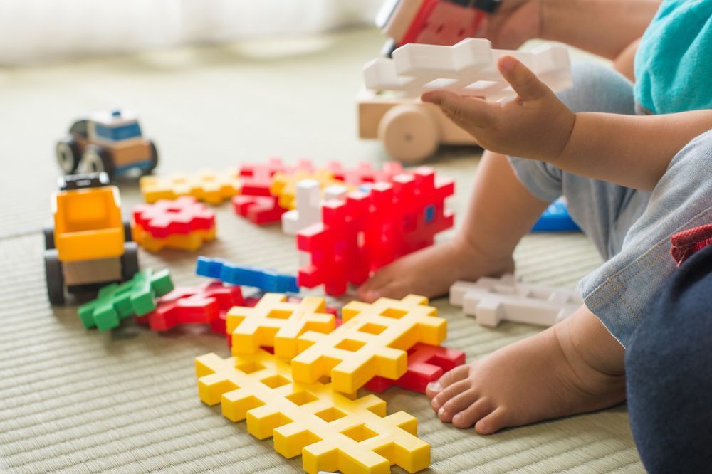 A Child is Playing With Toys on the Floor — Woodlands Child Care Centre in East Albury, NSW
