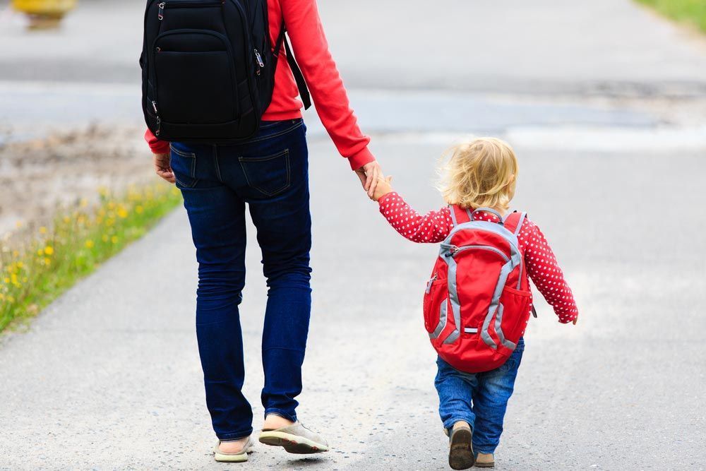 A Woman is Holding a Child's Hand Walking Down the Street — Woodlands Child Care Centre in East Albury, NSW