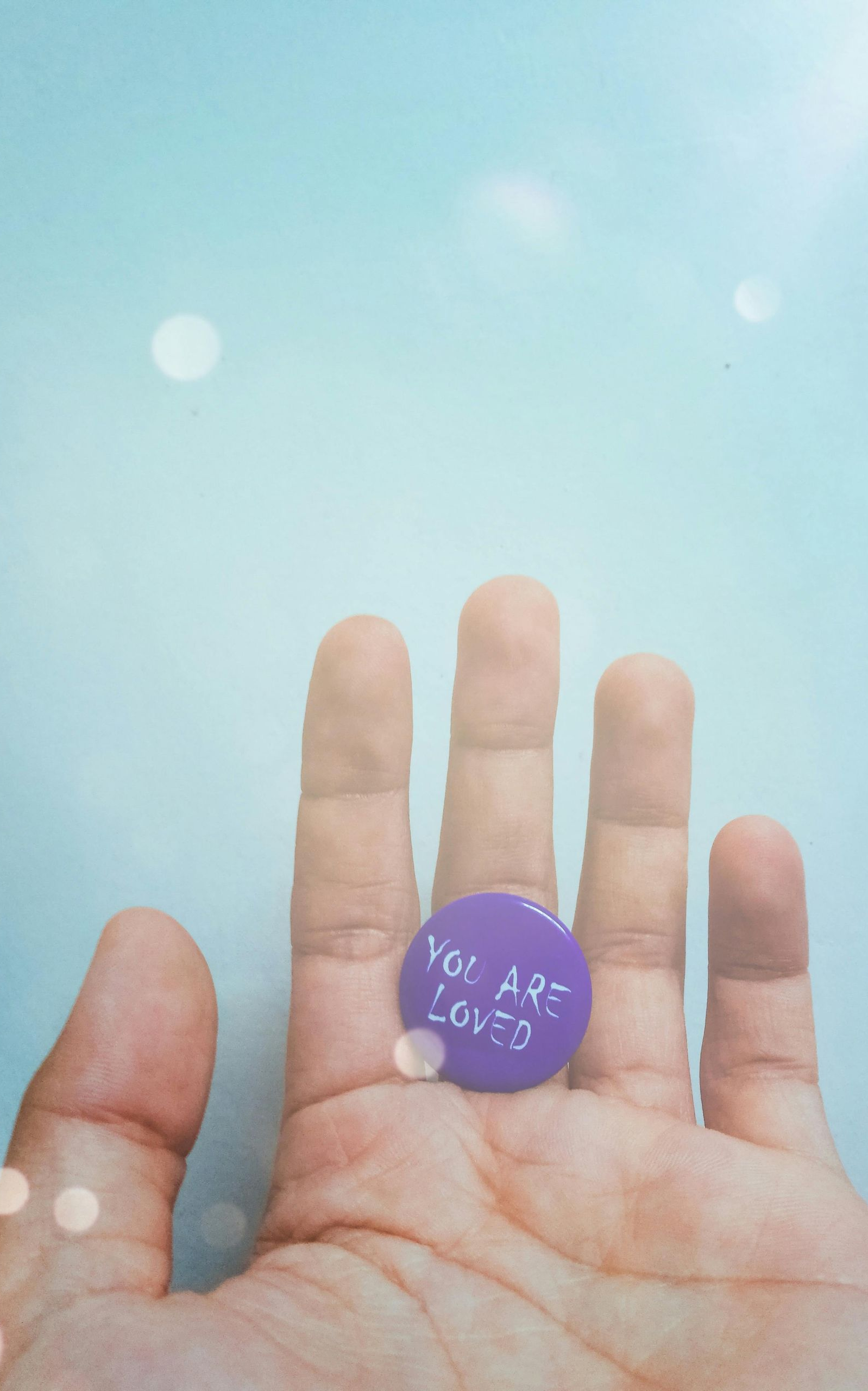 Hand holding a purple circle with the words 