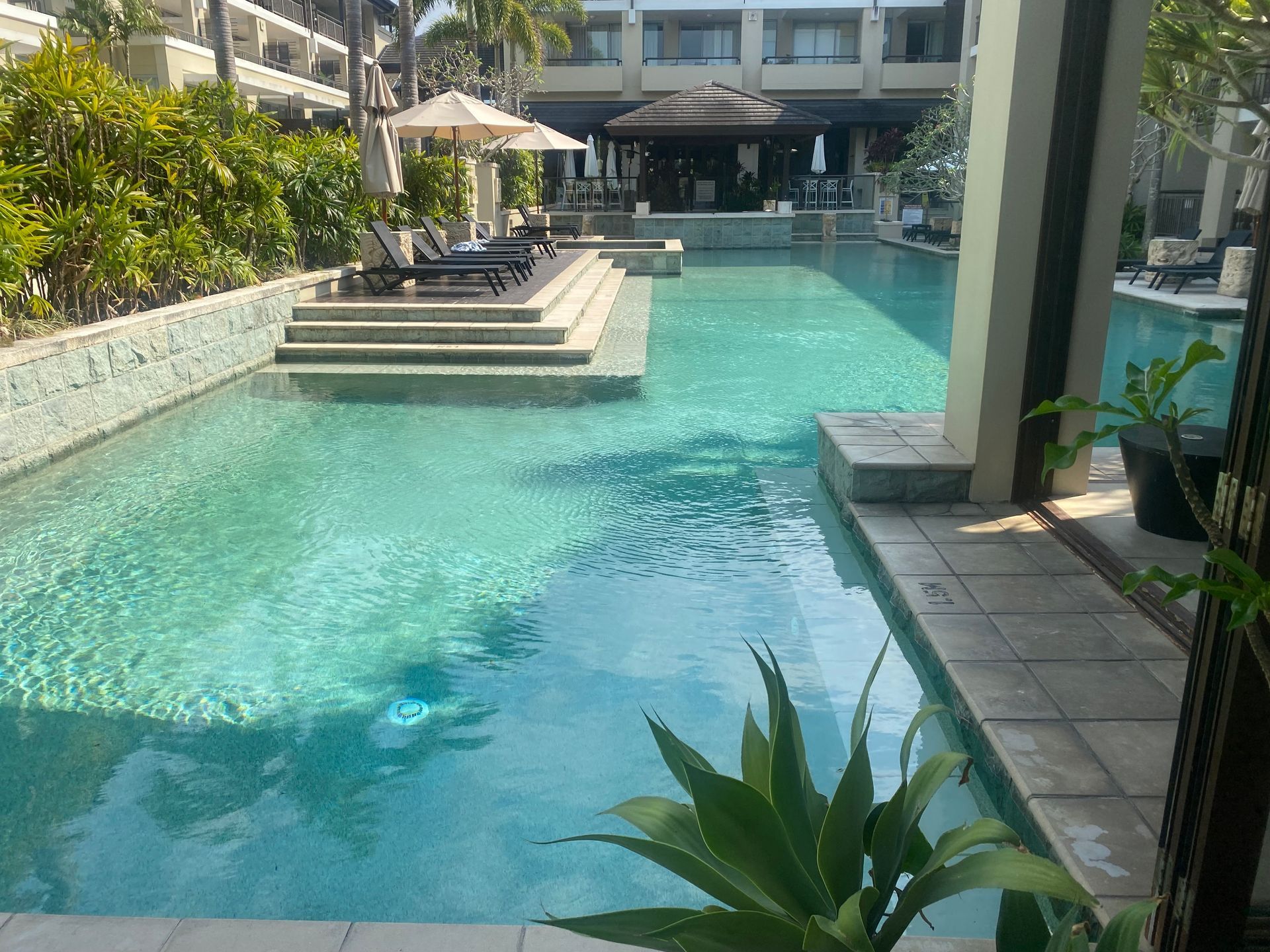 A Person is Testing the Water in a Swimming Pool With a Test Stick — Tweed Coast Pool Care in Currumbin Valley, QLD