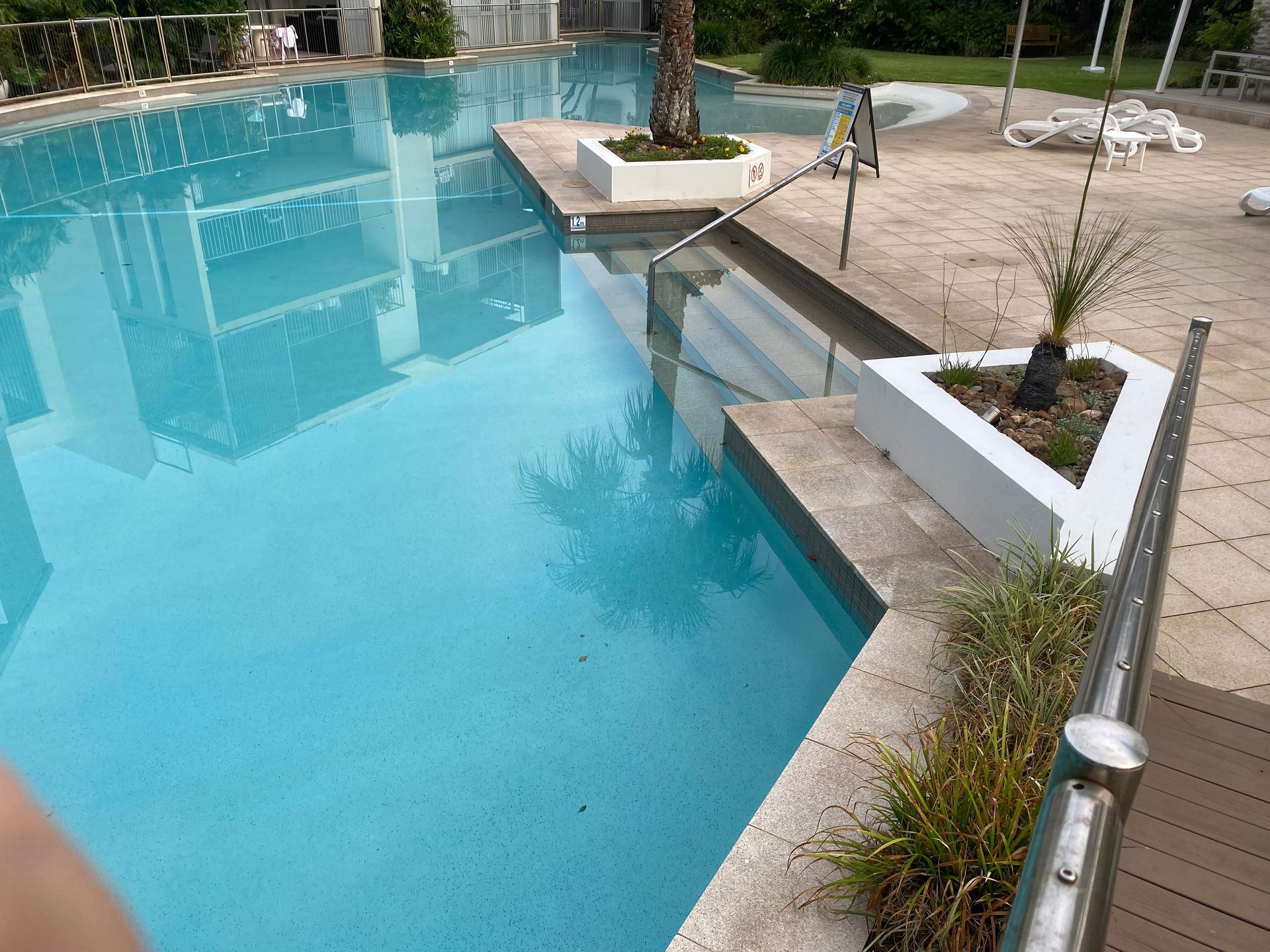 A Vacuum Cleaner is Sitting on the Side of a Swimming Pool — Tweed Coast Pool Care in Uki, NSW