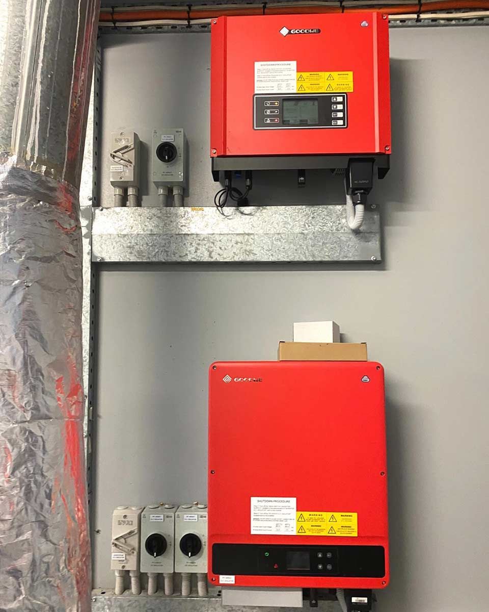 Two Red Solar Panels Are Hanging On A Wall — CJ Electrical & Solar In Aberglasslyn, NSW