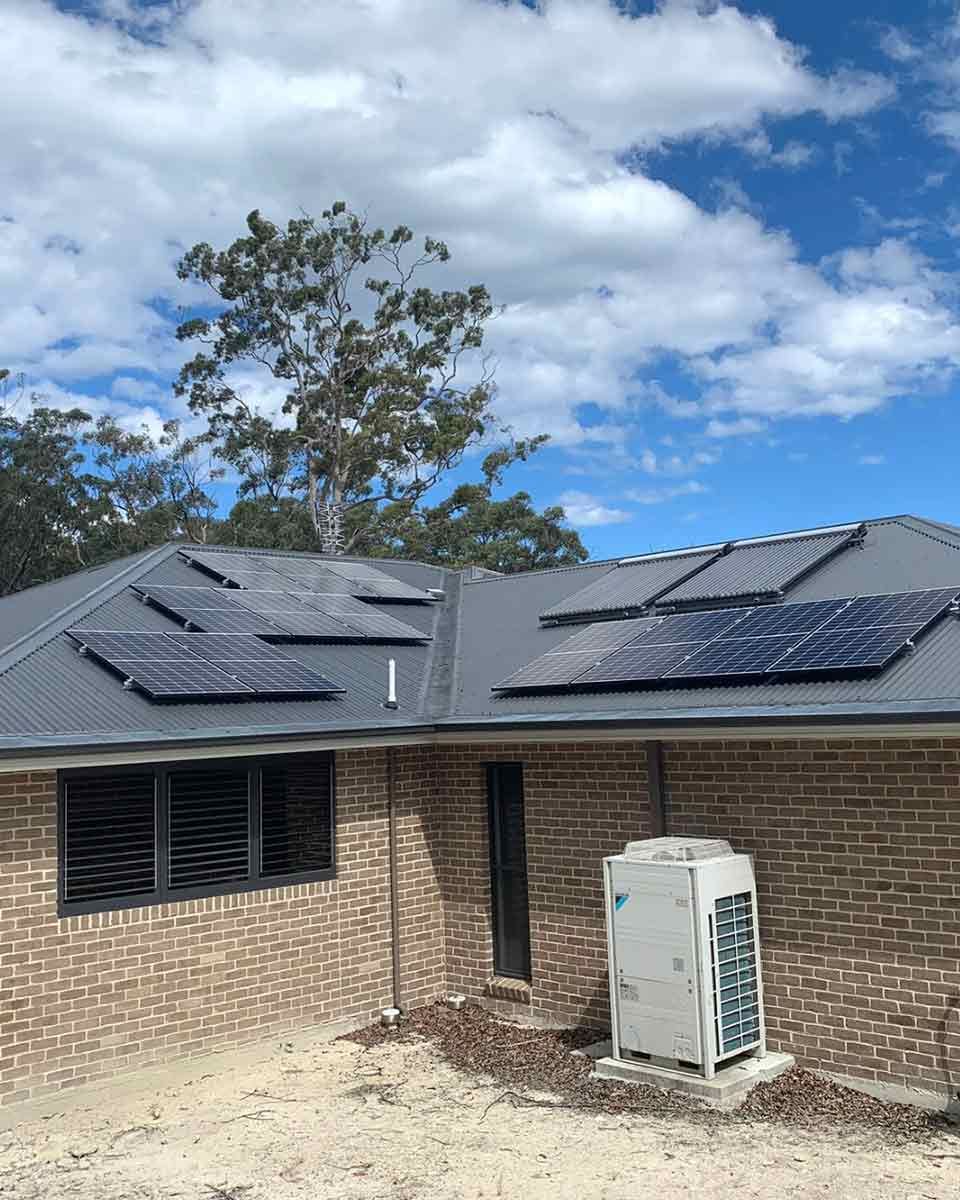 A Brick House With Solar Panels On The Roof — CJ Electrical & Solar In Lambton, NSW