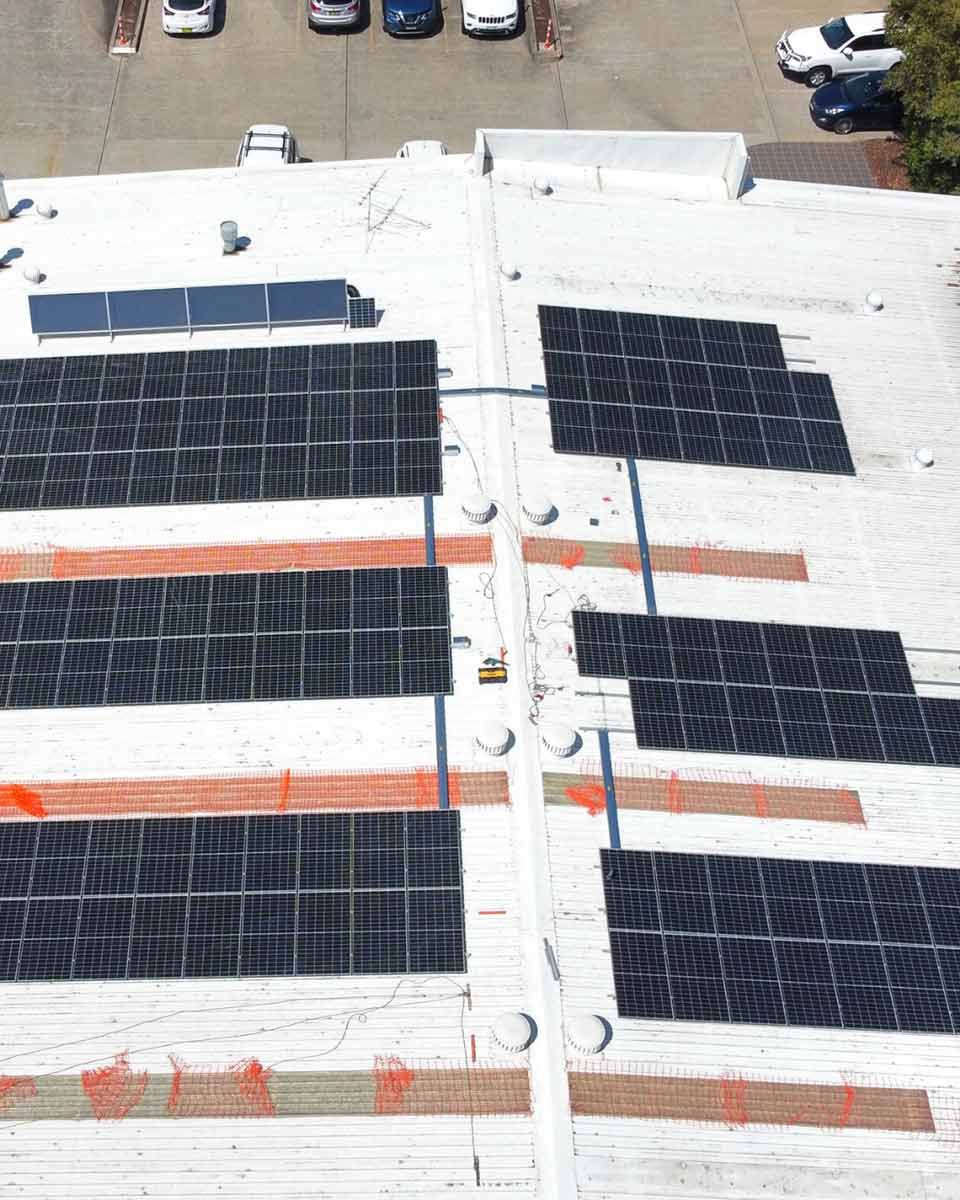 An Aerial View Of A Building With Solar Panels On The Roof — CJ Electrical & Solar In Warners Bay, NSW