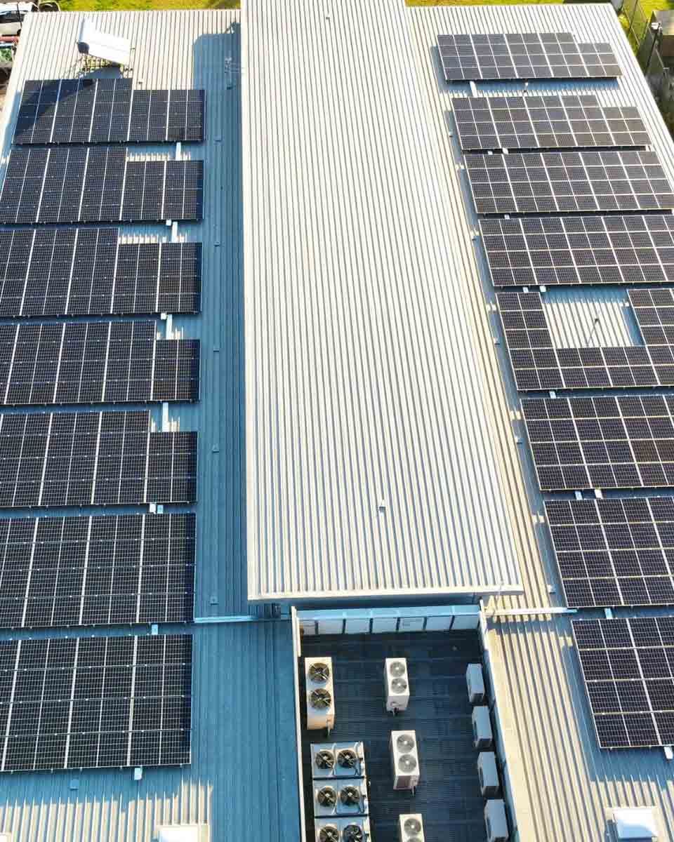 An Aerial View Of A Building With A Lot Of Solar Panels On The Roof — CJ Electrical & Solar In Singleton, NSW