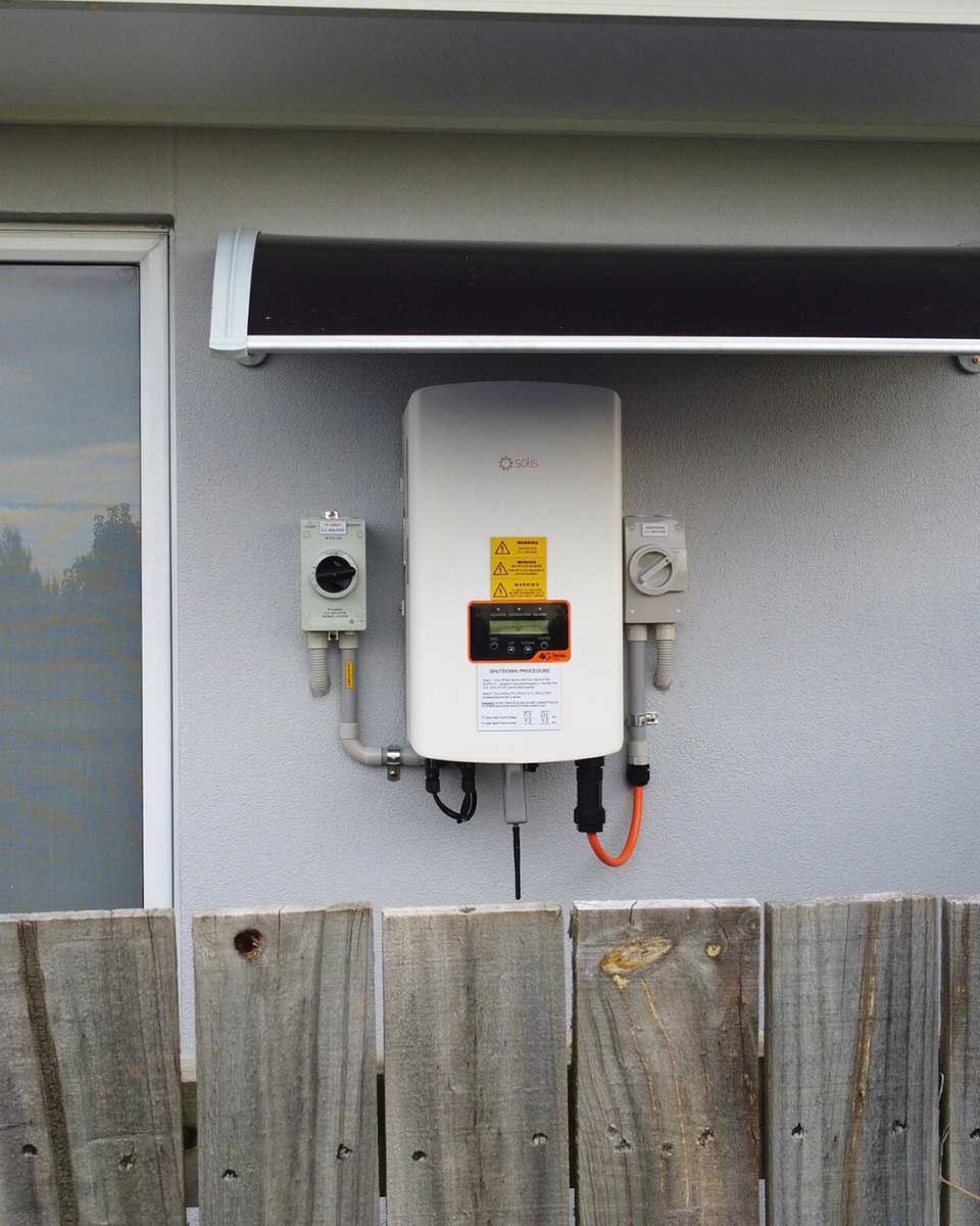 A Solar Panel Is Mounted On The Side Of A Building — CJ Electrical & Solar In Cooranbong, NSW