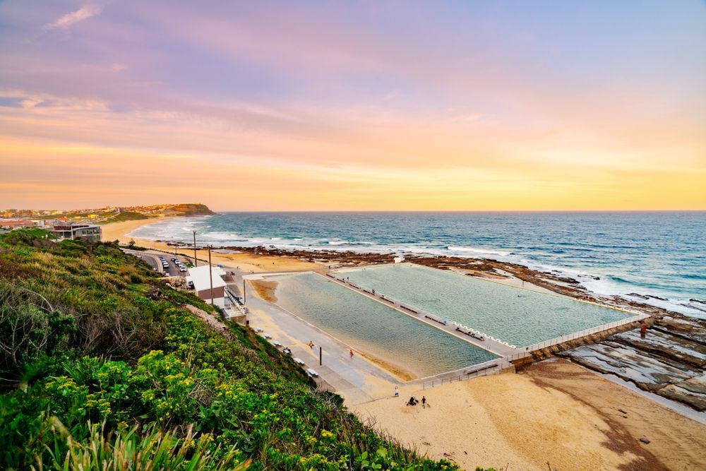 An Aerial View Of A Swimming Pool On The Beach At Sunset — CJ Electrical & Solar In Merewether, NSW
