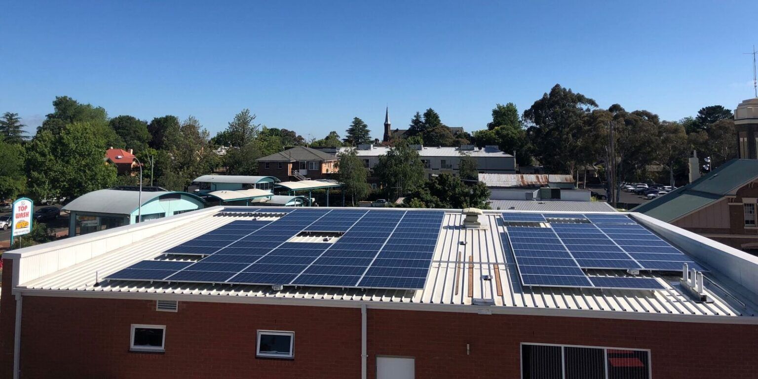 A Row Of Solar Panels On The Roof Of A Building — CJ Electrical & Solar In Cardiff, NSW