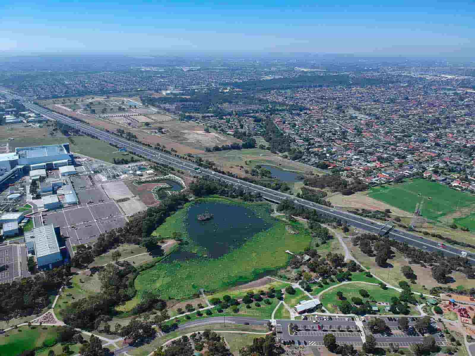 An Aerial View Of A City With A Lake And A Highway — CJ Electrical & Solar In Broadmeadow, NSW