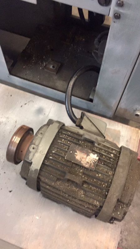 An old motor is sitting on a table next to a machine.