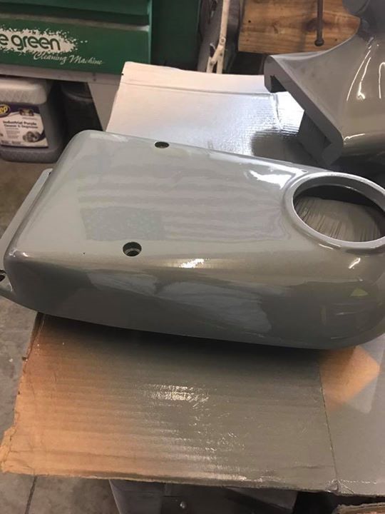 A gray object is sitting on top of a piece of cardboard.