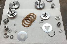 A bunch of metal parts are sitting on a piece of paper on a table.