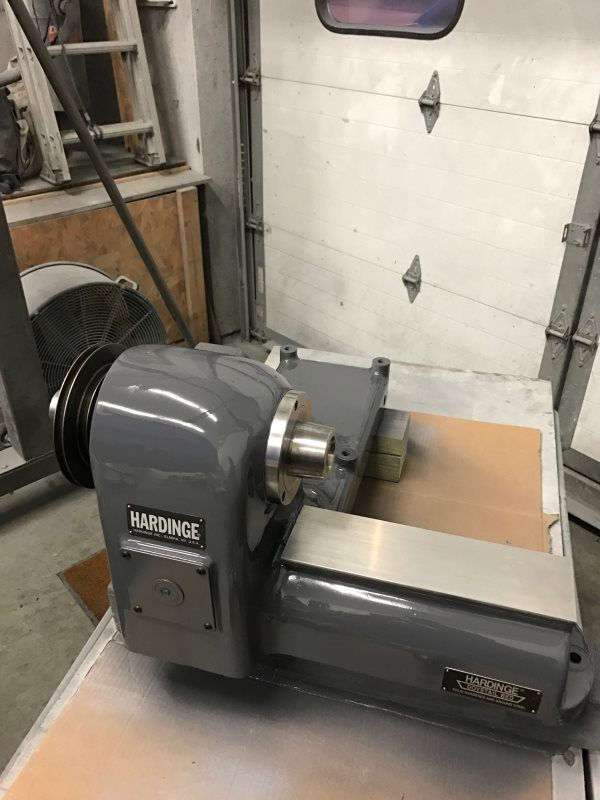 A lathe is sitting on top of a table in a garage.