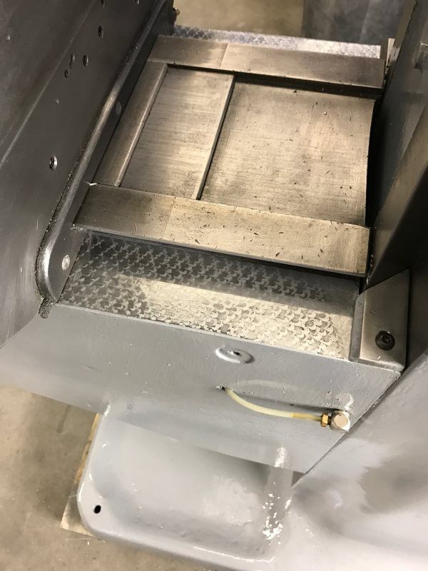 A stainless steel machine is sitting on top of a concrete floor.