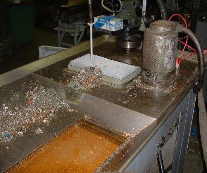 A machine is cutting a piece of metal on a table.