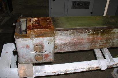 A rusty piece of metal is sitting on top of a white table.