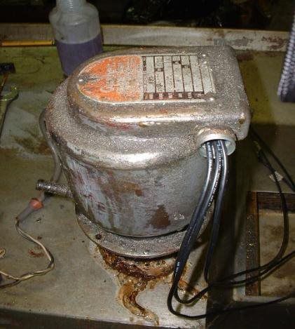 A dirty machine with a label on it is sitting on a table.