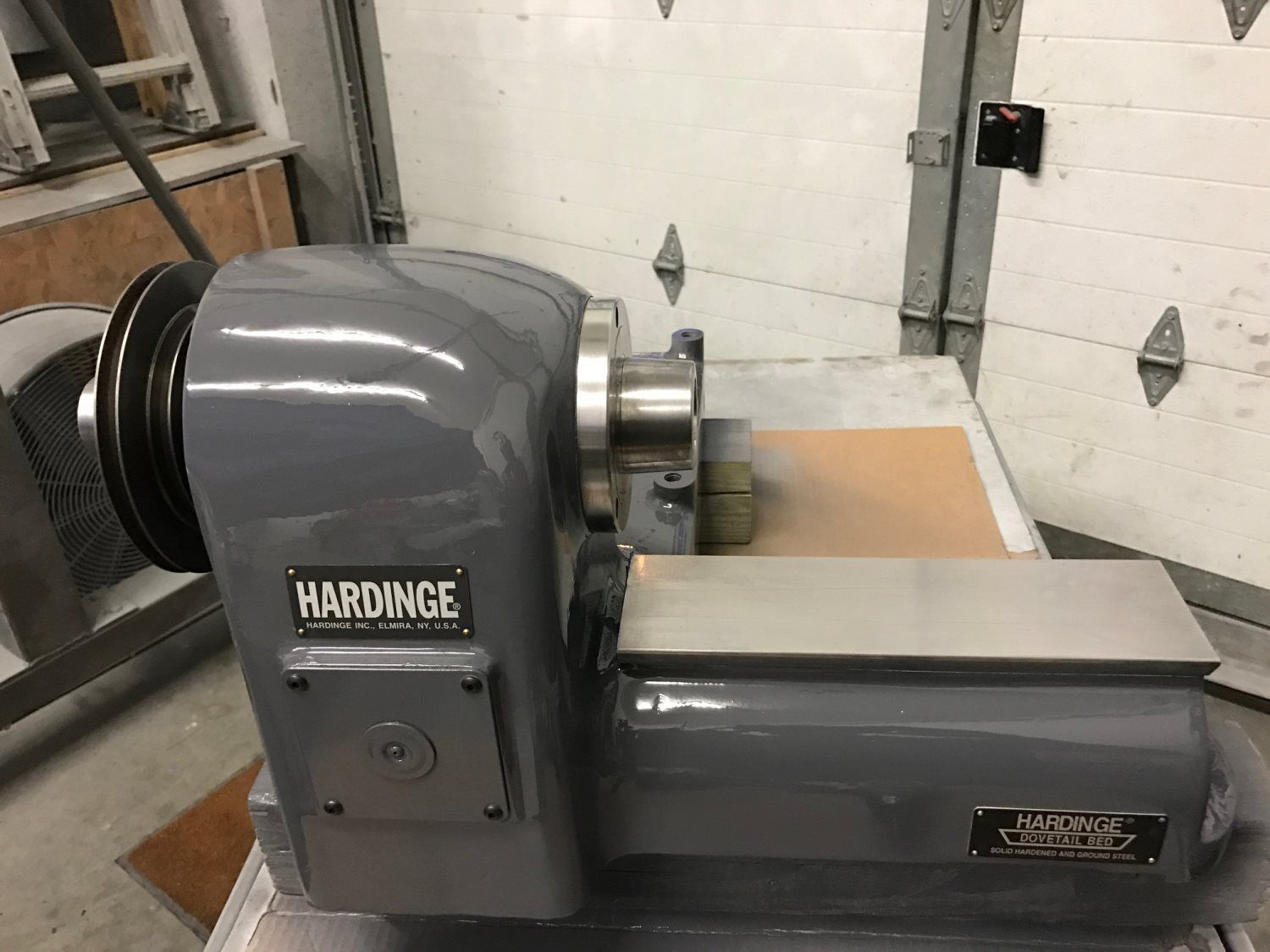 A hardinge lathe is sitting on a table in a garage.