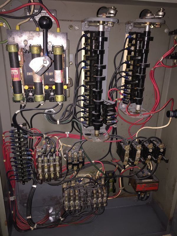 A close up of a electrical box with a lot of wires coming out of it.