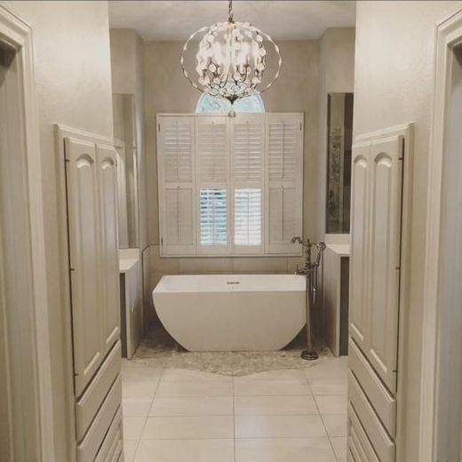 A bathroom with a tub and a chandelier hanging from the ceiling