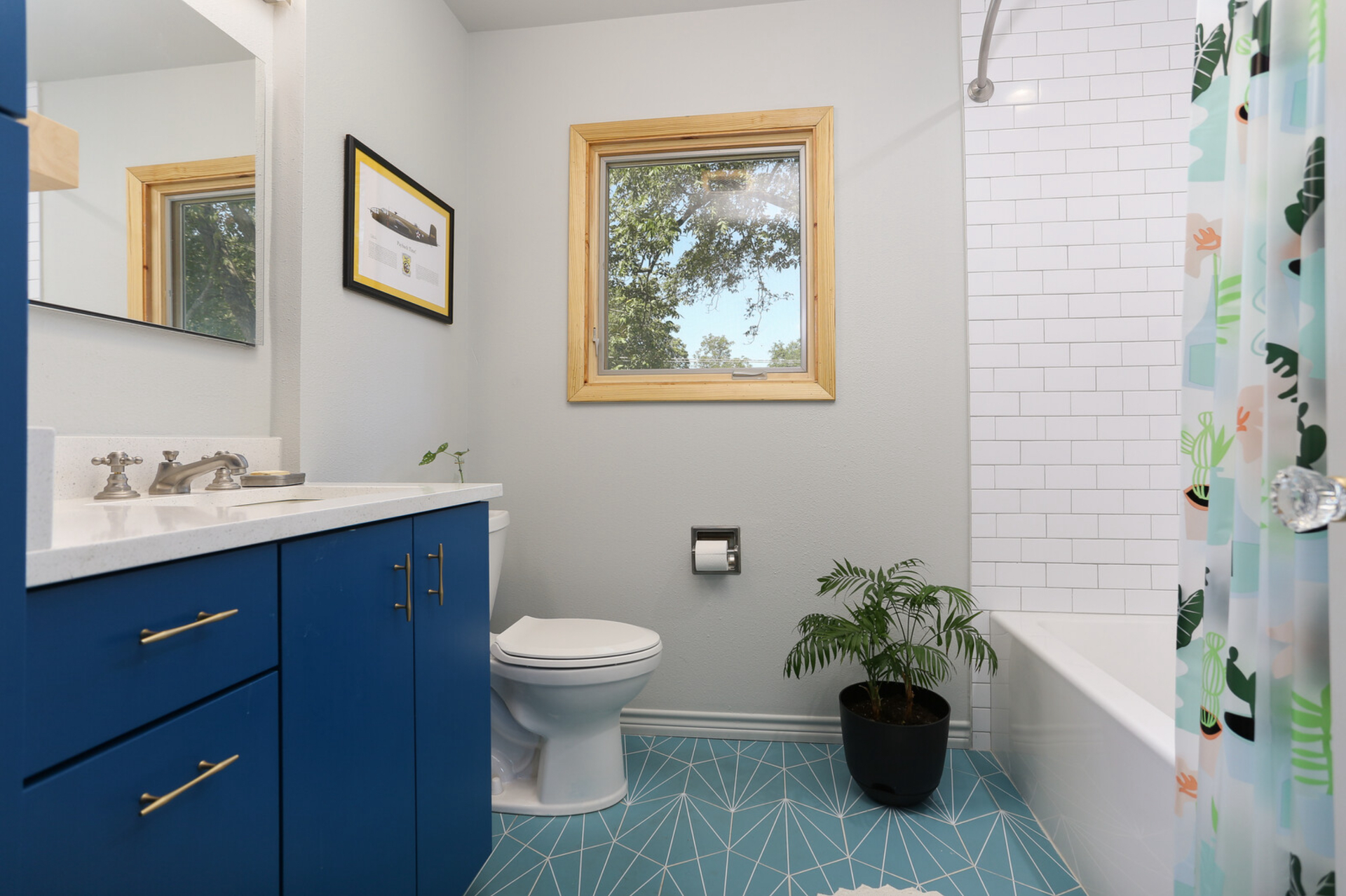 A bathroom with a toilet , sink , shower and window.