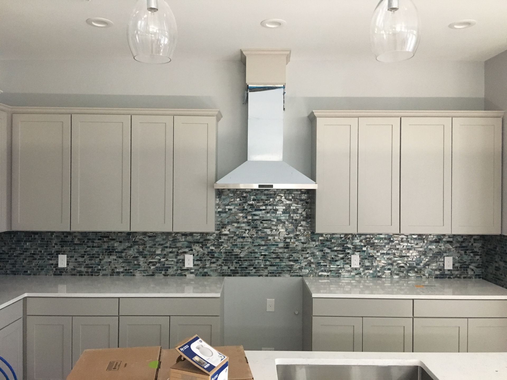 A kitchen with white cabinets and a stainless steel sink