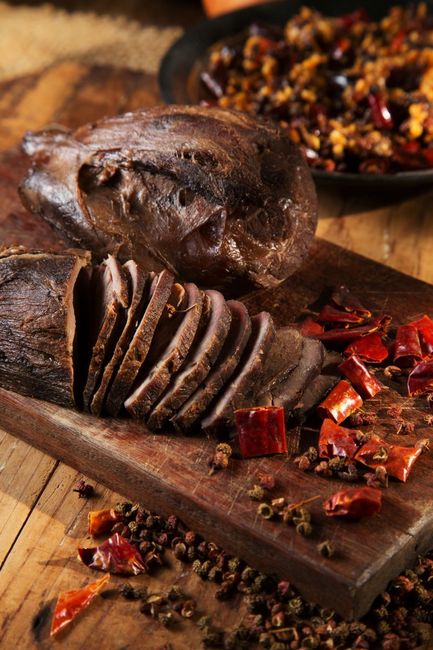 A piece of meat is sitting on top of a wooden cutting board.