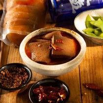 A bowl of food is sitting on top of a wooden table.
