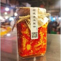 A jar of food with chinese writing on it is sitting on a table.