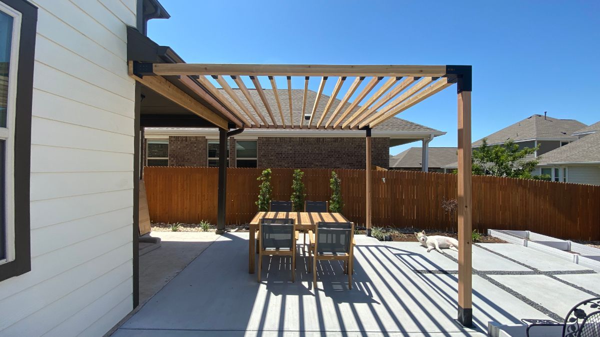 a patio with a table and chairs under a pergola