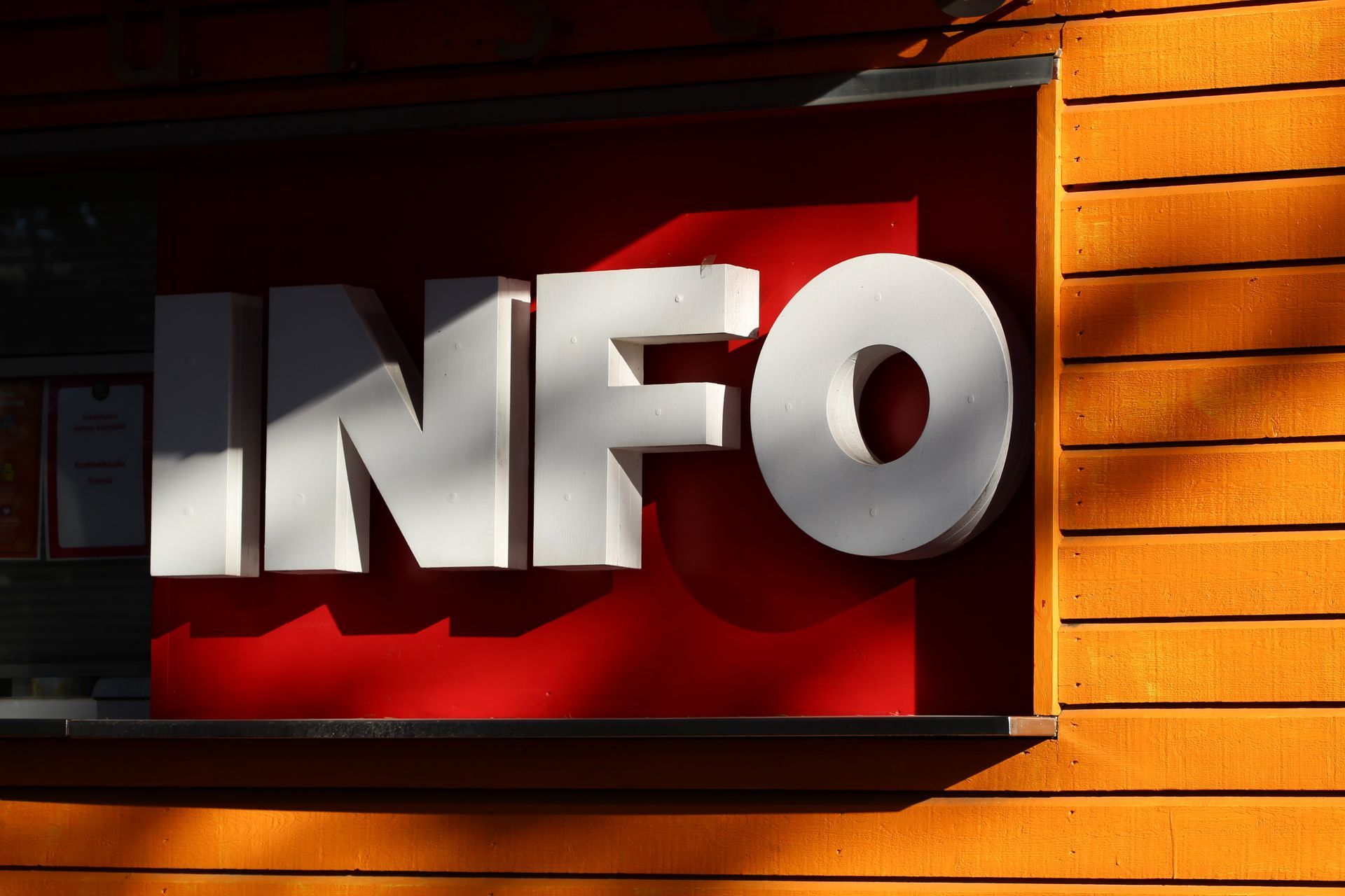 Photograph of a red and white sign, depicting the word 'INFO'