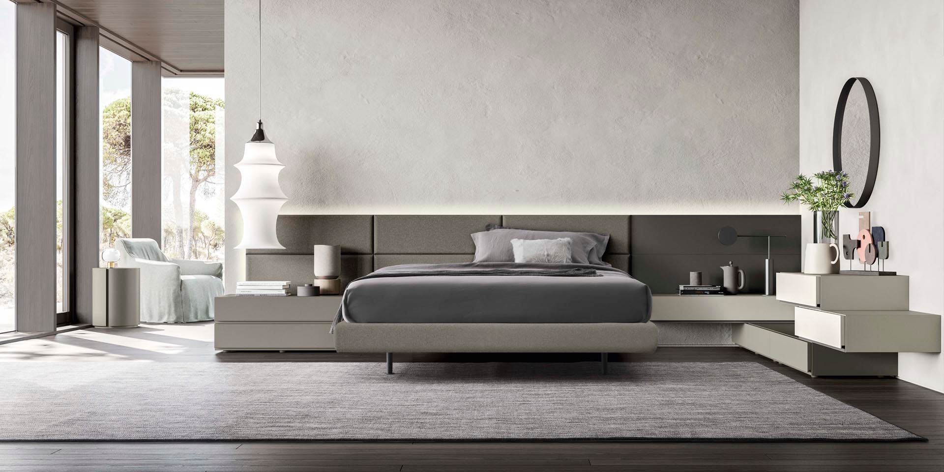 Una camera da letto con un letto, comodini, un tappeto e uno specchio.