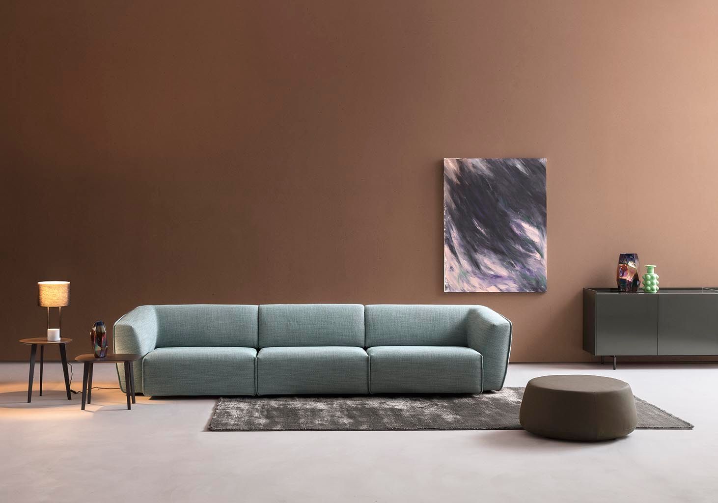 Un soggiorno con un divano blu e un dipinto sul muro