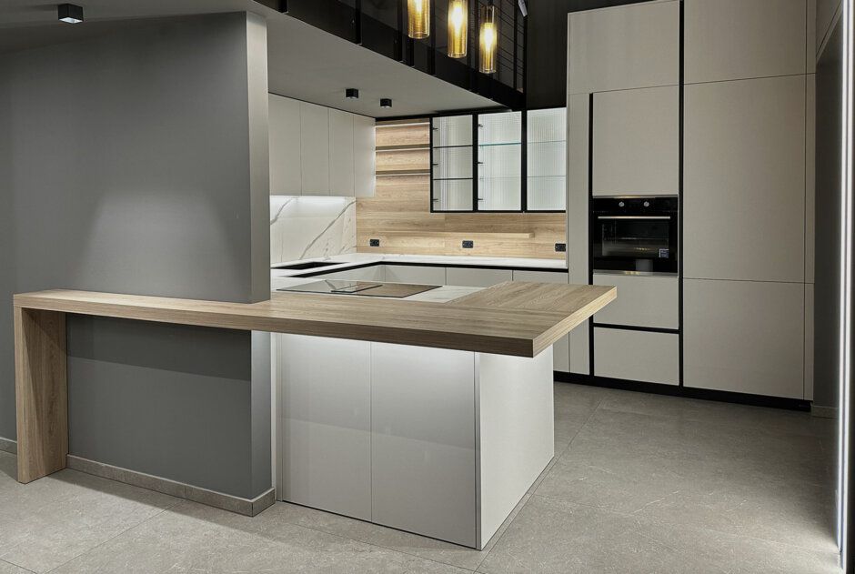 Una cucina con mobili bianchi e un piano di lavoro in legno.