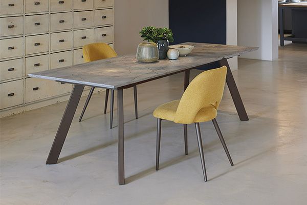 Un tavolo da pranzo con due sedie gialle in una stanza.