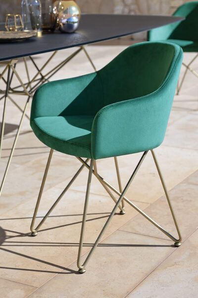 Una sedia verde è seduta davanti a un tavolo