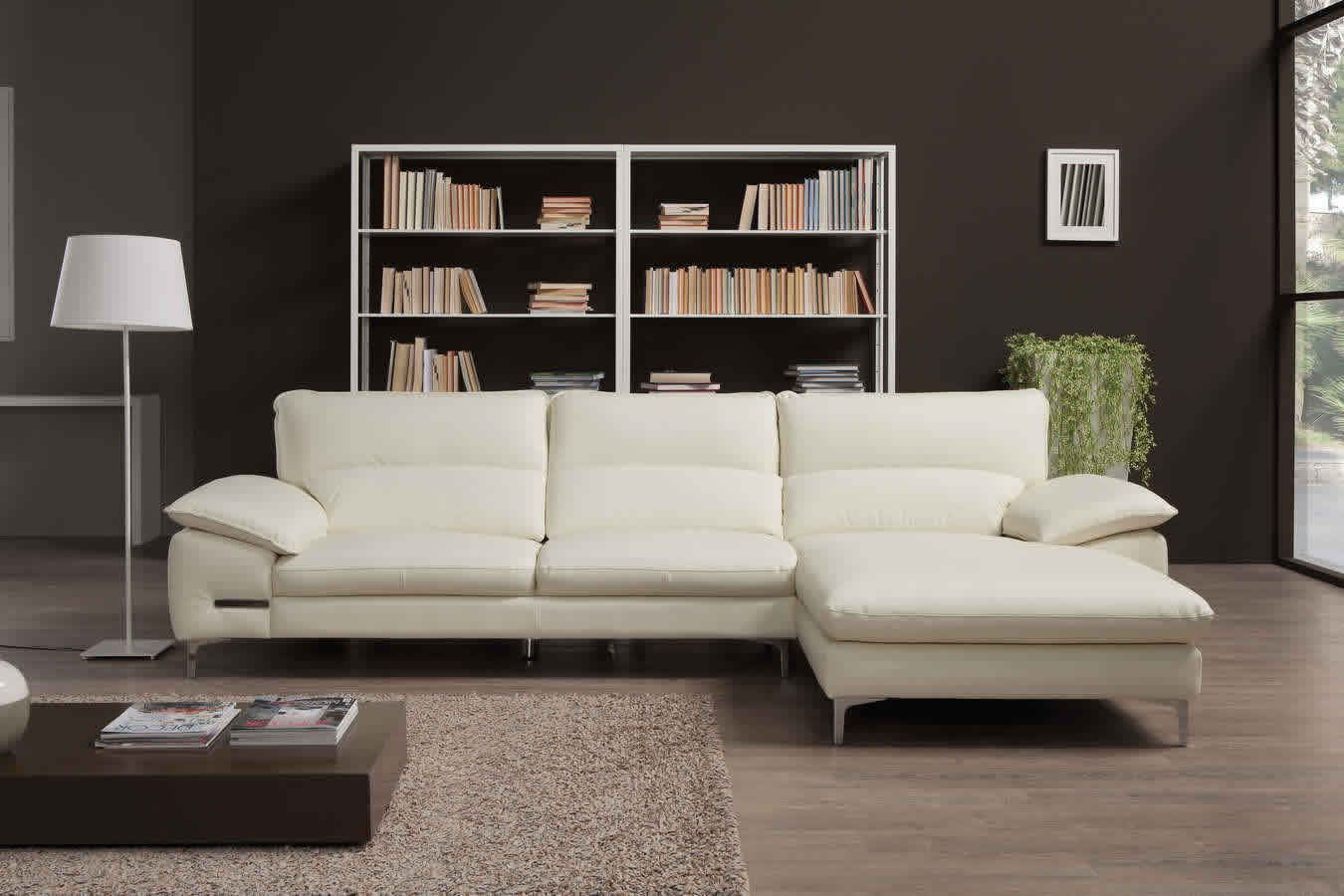 Un soggiorno con un divano componibile bianco e una lampada