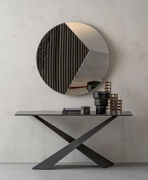 Un tavolo consolle con uno specchio rotondo sopra