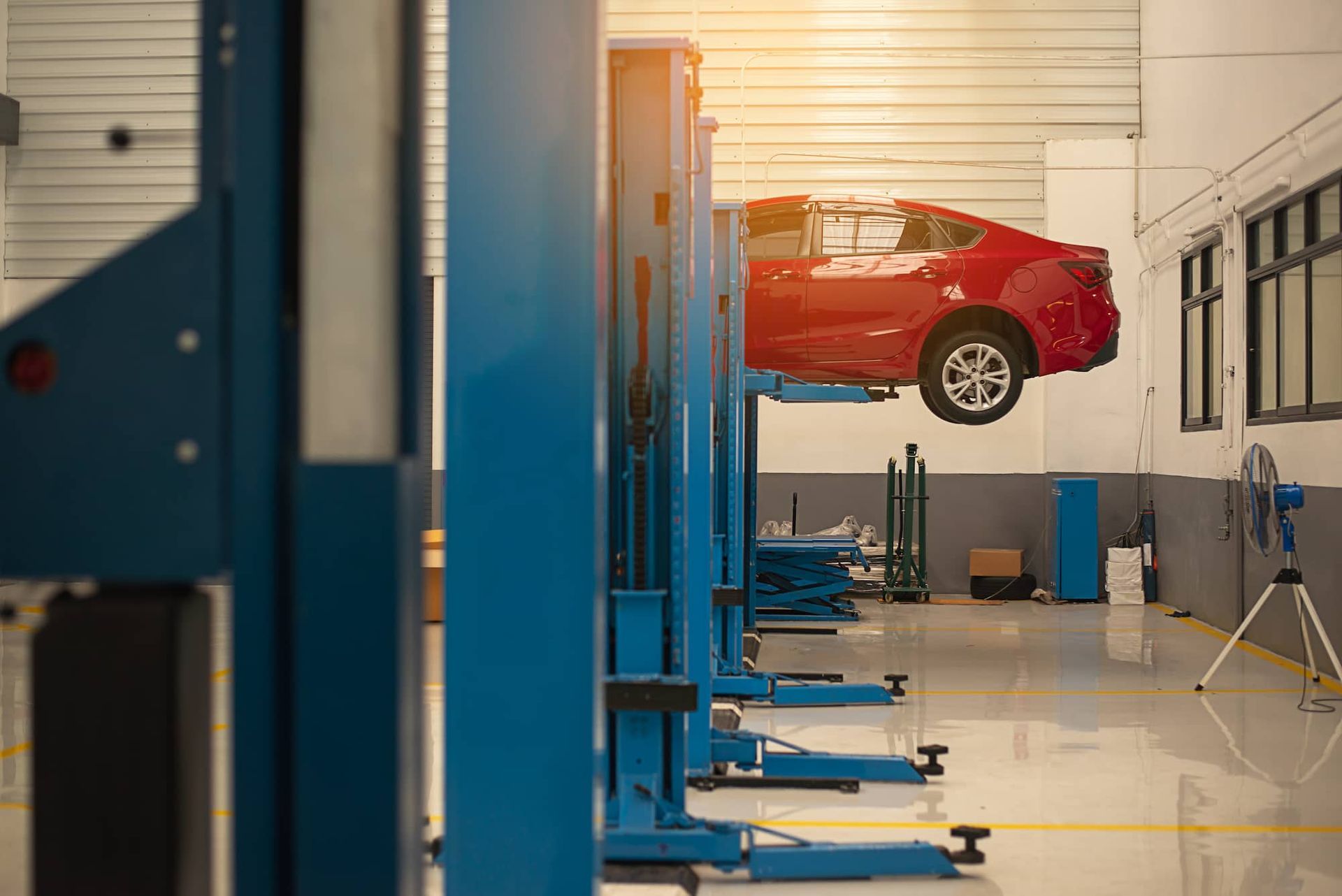 A Red Car Is Sitting On A Lift In A Garage — Berry Automotive Repairs In Berry, NSW