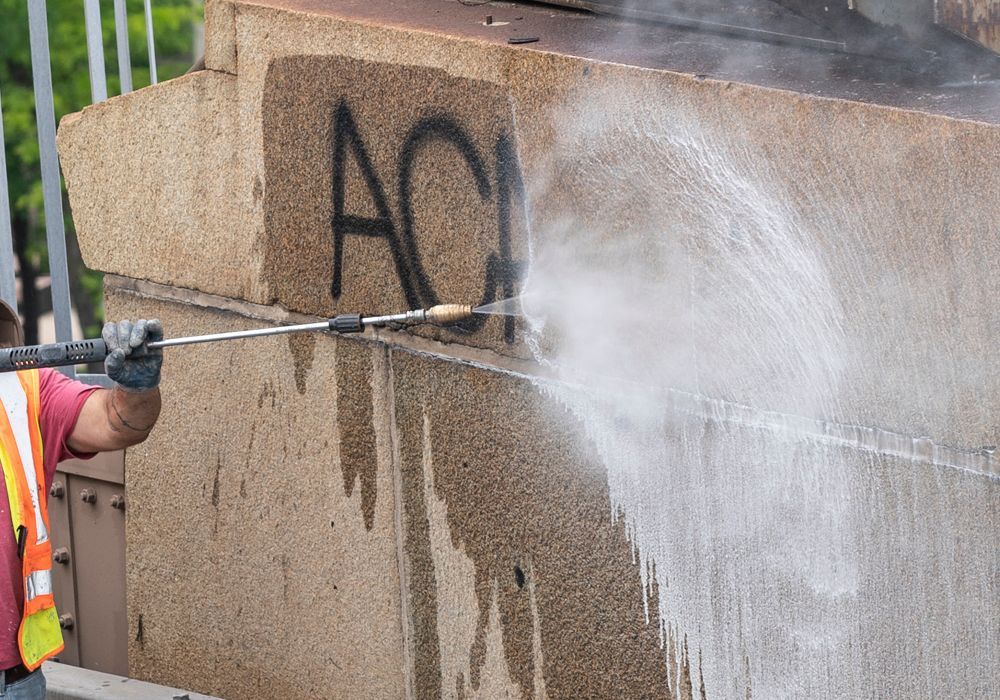 Professional Worker Removing Graffiti on the Wall