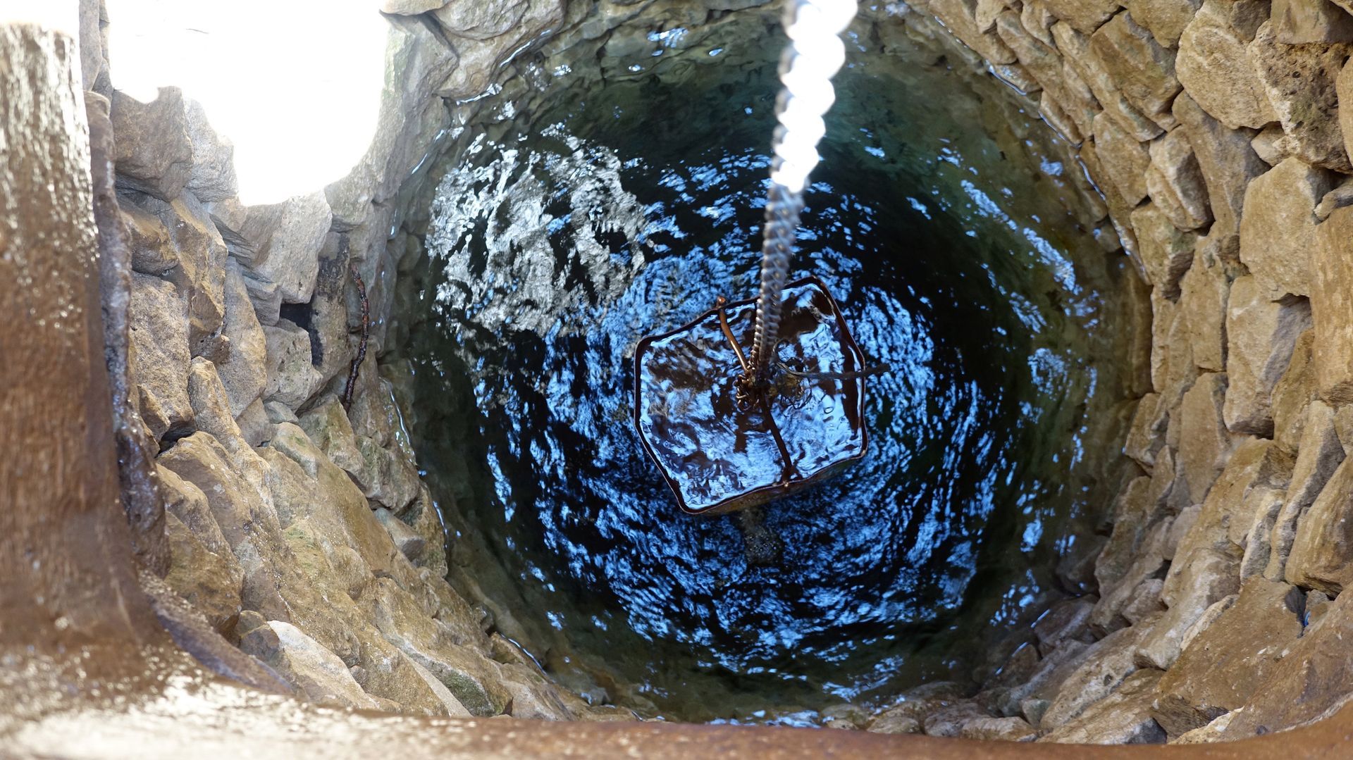 A water well with a pump above a hole in the ground, representing water well contractor services.