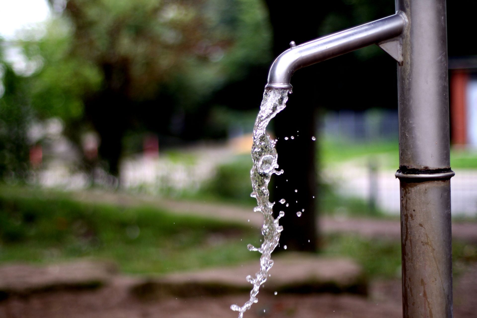 A close-up of clean water flowing from a tap with local water well contractor support. A close-up of clean water flowing from a tap with local water well contractor support.